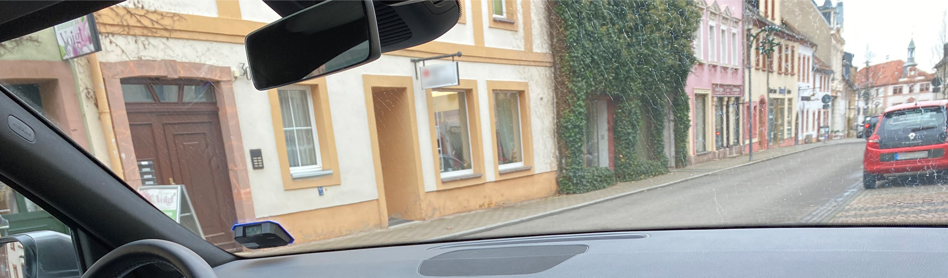 Das Bild zeigt denn Innenraum des Fahrschulautos der Fahrschule Mirko Schulz Geithain. Der Blick richtet sich Richtung Frontscheibe durch die man die Innenstadt Geithain sieht.